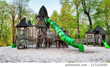 A vibrant playground with a large green slide and castle structure 127220564