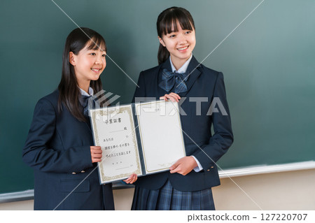 高中生/女孩拿著畢業證書站在教室黑板前（畢業生/畢業典禮/畢業） 127220707