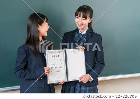 高中生/女孩拿著畢業證書站在教室黑板前（畢業生/畢業典禮/畢業） 127220709
