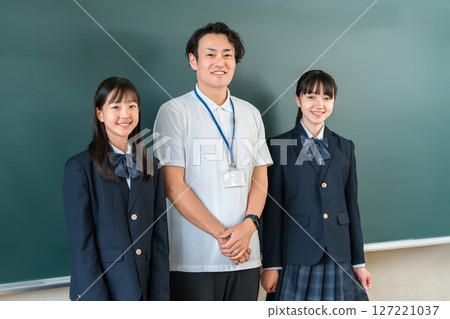 教室黑板前,一位男老師和一群小學、國中和高中的女生 教室黑板前,一位男老師和一群小學、國中和高中的女生 127221037