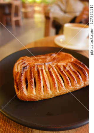 A Delicious Pastry Beautifully Plated on a Rustic Plate Next to Coffee 127221115