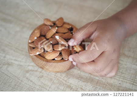 Close up of child hand pick almond nut Close up of child hand pick almond nut 127221141