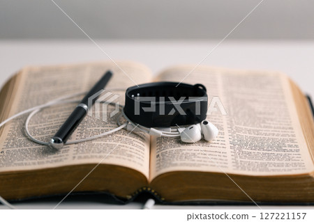 Close-up religious technology headphones pray bible church laptop Jesus Christ Holy Spirit Sunday service spiritual power blur background phone concept heaven belief gospel faith praise worship god 127221157
