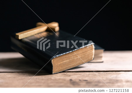 Religious belief concept Close up prayer Christian church service Bible Holy cross Spiritual power Blurred background Desk copy space Heaven God Catholic faith Praise book Jesus worship Gospel symbols 127221158