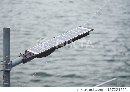Solar panel installation beside calm waterway 127221511