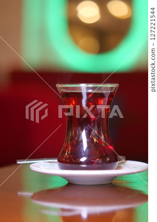 Turkish tea served in a traditional glass at a cozy cafe Turkish tea served in a traditional glass at a cozy cafe 127221544
