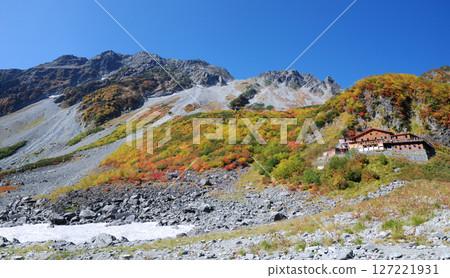 The first snow on the Hotaka mountains and autumn in Kamikochi, with autumn leaves decorating the Kitaho Karasawa hiking trail (best time to see) - wide panoramic view 127221931