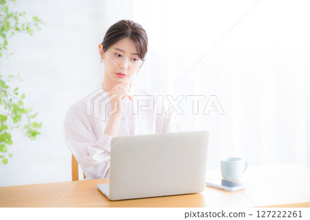 Thinking in front of the computer: The image of office casual wear for women in sheer shirts. What should I do about my job change? 127222261