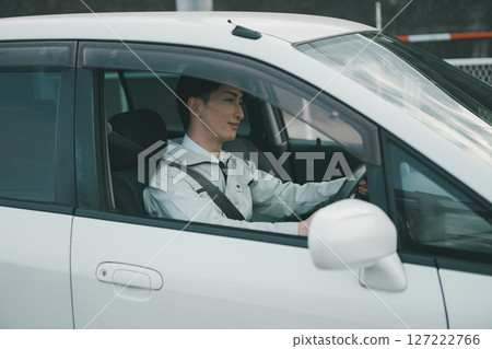 一名身穿工作服、繫領帶的男子駕車出行 127222766