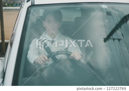 一名身穿工作服、繫領帶的男子駕車出行 127222769