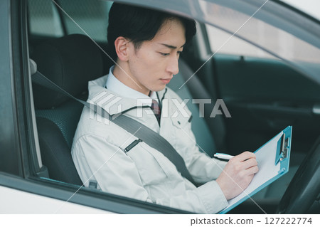 一名男子穿著工作服，打著領帶，在車上巡視 127222774