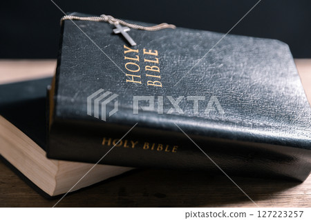 Religious belief concept Close up prayer Christian church service Bible Holy cross Spiritual power Blurred background Desk copy space Heaven God Catholic faith Praise book Jesus worship Gospel symbols 127223257