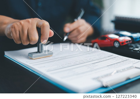 Businesswoman hand stamp approve on financial business approval document paper. Man hand accept permit contract agreement. Broker manager sign contract bank guarantee approved stamp application form Businesswoman hand stamp approve on financial business approval document paper. Man hand accept permit contract agreement. Broker manager sign contract bank guarantee approved stamp application form 127223340