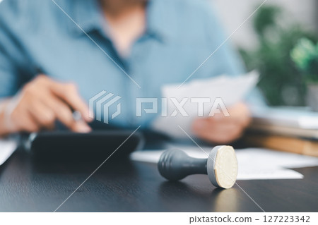 Businessman hands stamp approve on financial business approval document paper. Man hand accepted permit contract agreement. Broker manager sign contract bank guarantee approved stamp application form Businessman hands stamp approve on financial business approval document paper. Man hand accepted permit contract agreement. Broker manager sign contract bank guarantee approved stamp application form 127223342