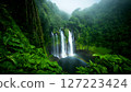 Lush Tropical Waterfall Cascading into a Plunge Pool with a Vibrant Rainbow Amidst Dense Green Foliage and Misty 127223424