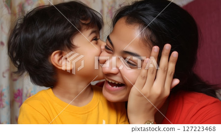 Mother and son share a joyful moment indoors full of laughter and affection during a cozy evening 127223468