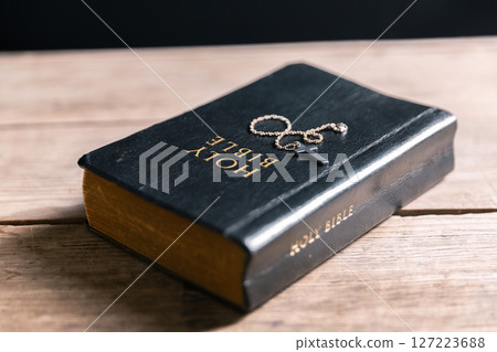 Religious belief concept Close up prayer Christian church service Bible Holy cross Spiritual power Blurred background Desk copy space Heaven God Catholic faith Praise book Jesus worship Gospel symbols 127223688