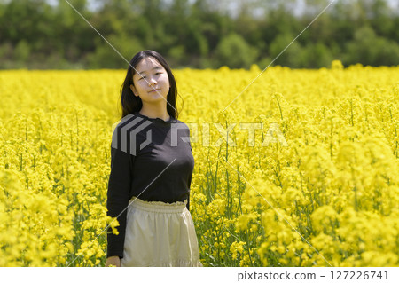 一名女子在盛開的油菜花田中觀光 一名女子在盛開的油菜花田中觀光 127226741