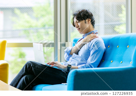 A man who uses a personal computer at a cafe 127226935