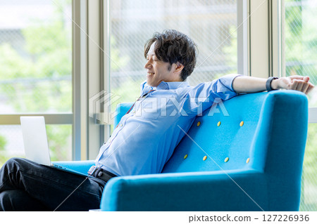 Businessman using laptop in lounge 127226936