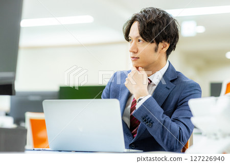 A businessman operating a personal computer in the office 127226940