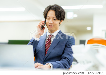 Businessman using a smartphone in the office 127226945