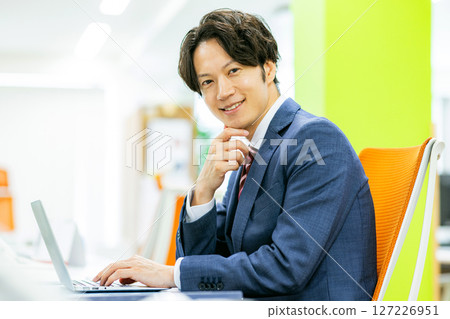 A young businessman working in the office 127226951