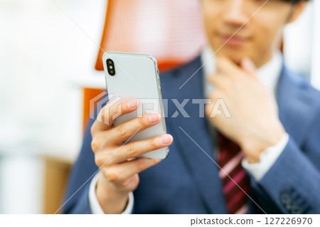 看智能手機的商人 127226970