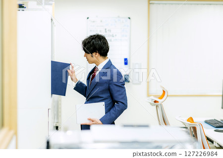 Male employee looking at company documents 127226984