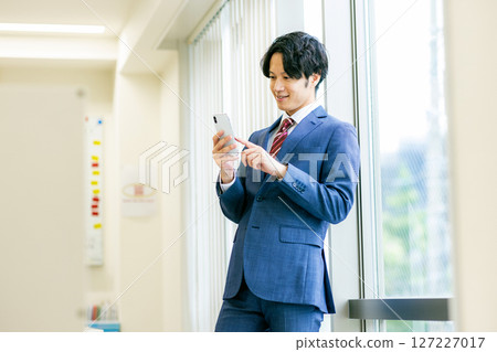 一個操作智能手機的人 127227017