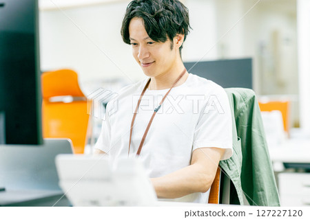 Young businessman headed to laptop Young businessman headed to laptop 127227120