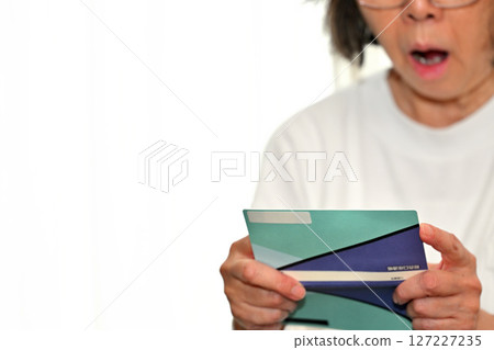 Seniors checking their savings passbook Seniors checking their savings passbook 127227235