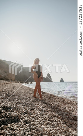 Woman Walking on a Rocky Beach 127227635