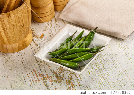 Hot spicy green chili pepper 127228392