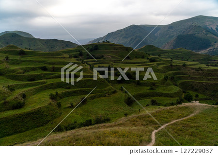 Chokhsky terraces Dagestan. Landscape of mountainous Dagestan with terraced fields and peaks mountains in the distance. Chokhsky terraces Dagestan. Landscape of mountainous Dagestan with terraced fields and peaks mountains in the distance. 127229037
