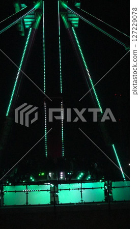 Ferris Wheel Night Illumination Lights Amusement Park: Teal-lit Ferris wheel structure at night, likely for entertainment. Ferris Wheel Night Illumination Lights Amusement Park: Teal-lit Ferris wheel structure at night, likely for entertainment. 127229078