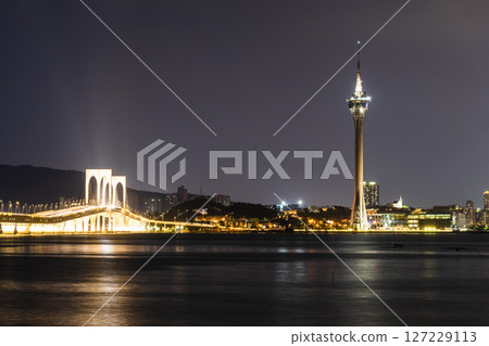 Beautiful night view of the Macau Tower and the Sai Van Bridge crossing Praia Grande Bay (Nam Van) and connecting Taipa Island and Macau Peninsula. Beautiful night view of the Macau Tower and the Sai Van Bridge crossing Praia Grande Bay (Nam Van) and connecting Taipa Island and Macau Peninsula. 127229113