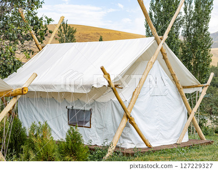 Modern white luxury tent. Glamping housing for summer vacation, camping holidays 127229327