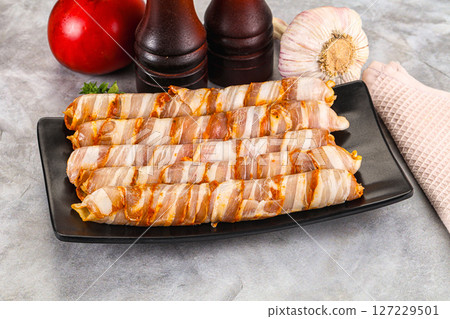 Raw sausages wrapped in bacon Raw sausages wrapped in bacon 127229501