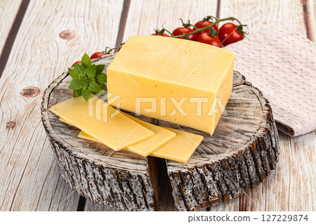 Yellow cheese piece with slices 127229874