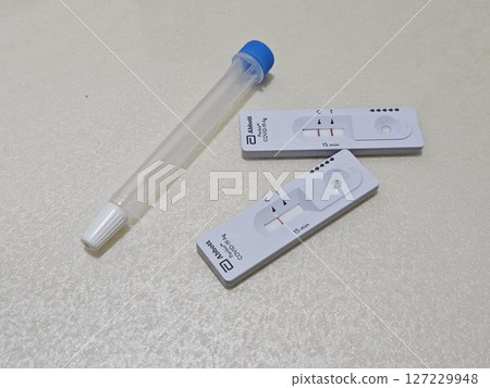 快速抗原檢測盒附有控制線和檢測線,旁邊是中性背景上的無菌鼻拭子,展示了在家中進行 COVID-19 快速抗原檢測盒附有控制線和檢測線,旁邊是中性背景上的無菌鼻拭子,展示了在家中進行 COVID-19 127229948