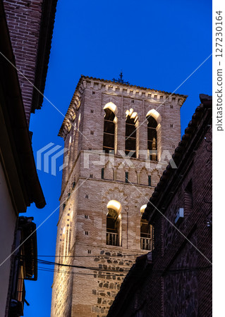 A brick bell tower rises against the evening sky in Toledo, Spain, exhibiting Moorish architecture. A brick bell tower rises against the evening sky in Toledo, Spain, exhibiting Moorish architecture. 127230164