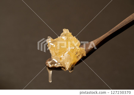 Close-up of honeycomb on a wooden spoon 127230370
