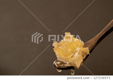 Close-up of honeycomb on a wooden spoon 127230371