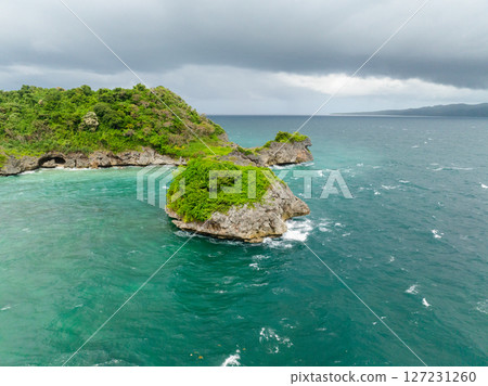 Beautiful sea waves crashing on rocks and islets under cloudy sky. Boracay, Philippines. 127231260
