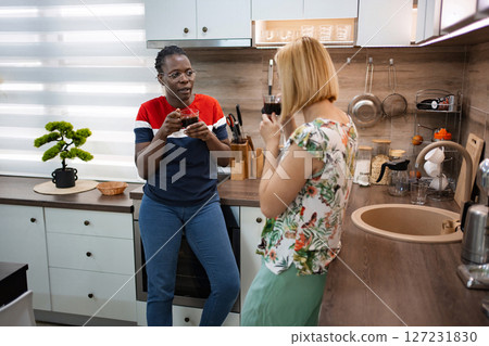 Friends share stories and warmth over coffee in a cozy kitchen 127231830