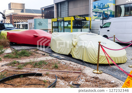 Dubai, UAE - September 26, 2024, Expensive luxury sports cars among construction debris. Editorial Dubai, UAE - September 26, 2024, Expensive luxury sports cars among construction debris. Editorial 127232346