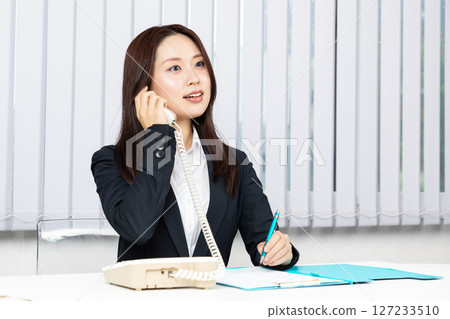 Asian woman taking notes on phone call 01 Asian woman taking notes on phone call 01 127233510