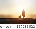 Shepherd Jesus Christ walking with sheep in wide meadow, silhouette with brilliant sun sunset, Jesus and sheep background 127233622