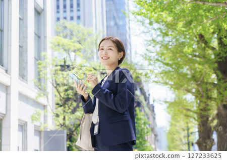 一位年輕的女商人在辦公區用智慧型手機搜索 127233625